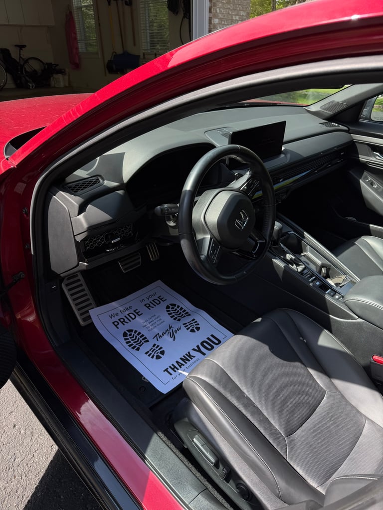 Interior of red sports car with steering wheel and note on drivers seat about pride and unity