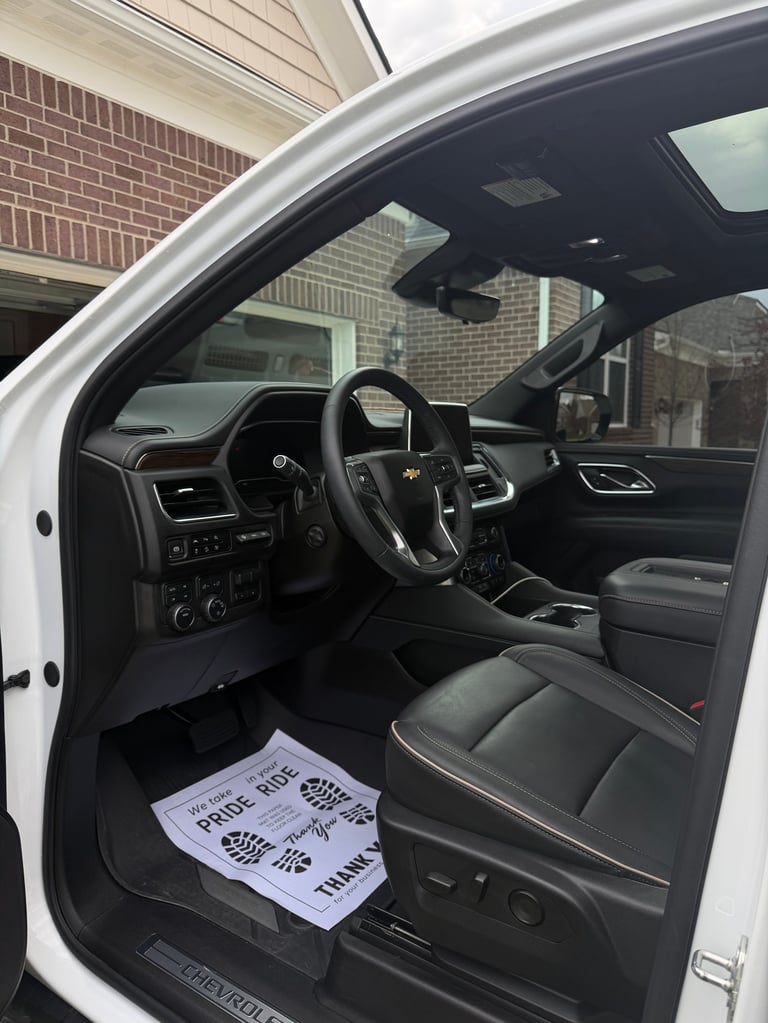 Interior view of a white Chevrolet pickup truck with black leather seats and dashboard